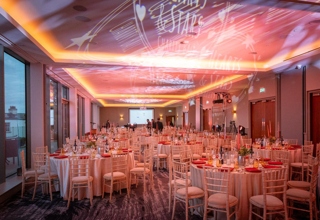 A gala dinner room set with tables and candles