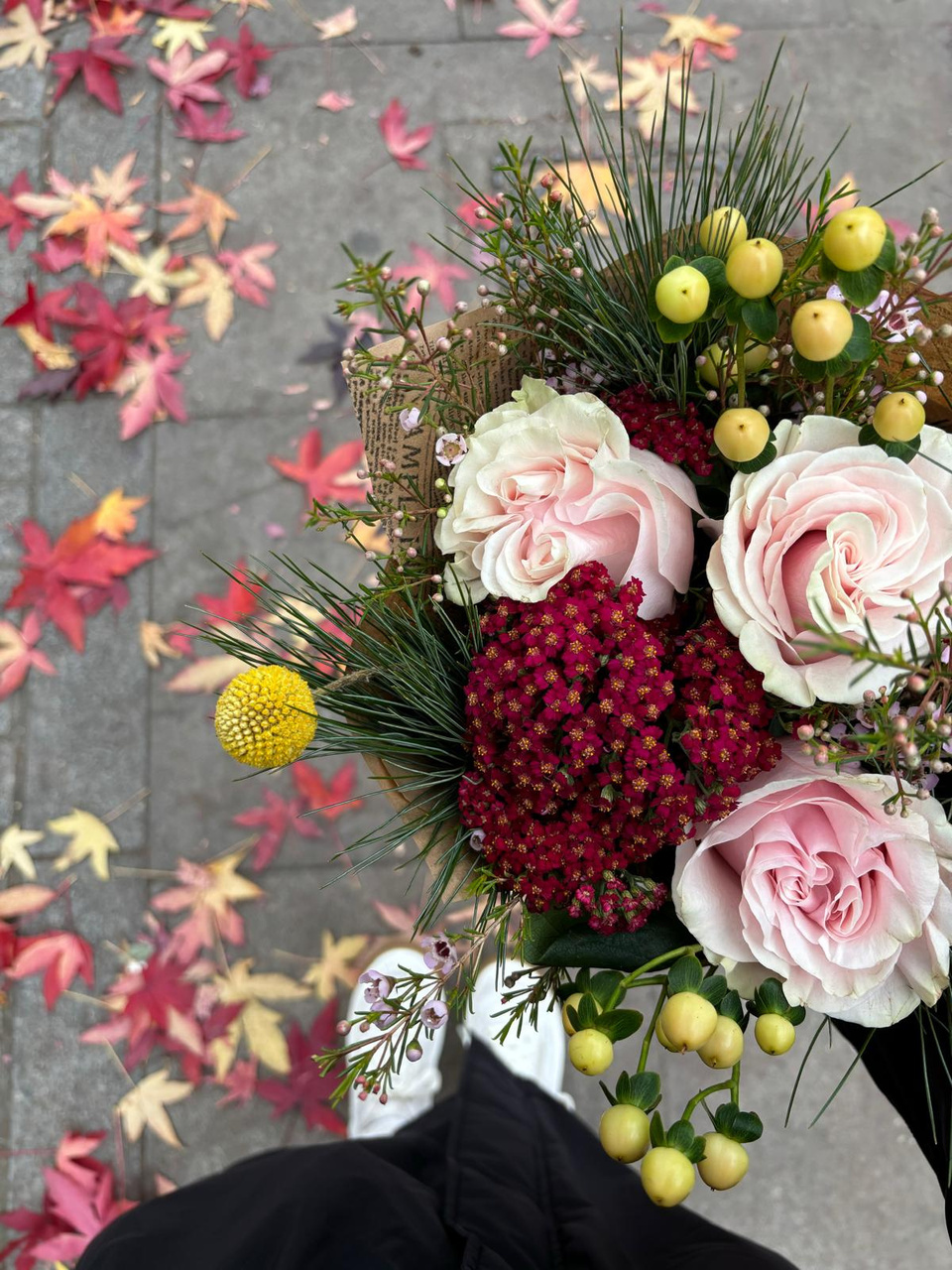 Pink roses and hypericum on a stone wall