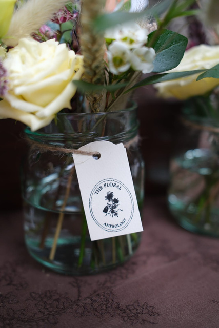 A white rose in a jar with a hand-tied label