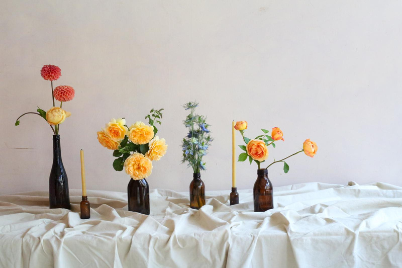 Single stems arranged in bud vases on a table