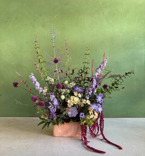A pink and lavender arrangement on a green backdrop