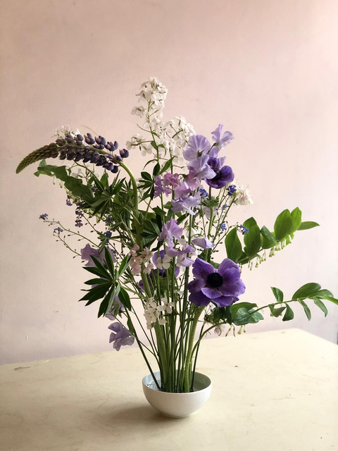 A purple and cream arrangement on a blush backdrop