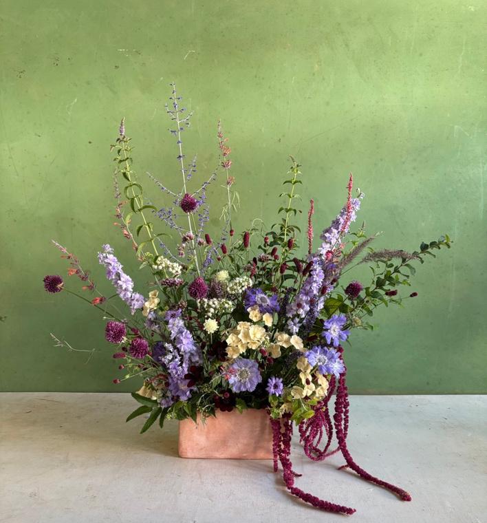A garden-style arrangement against a green wall