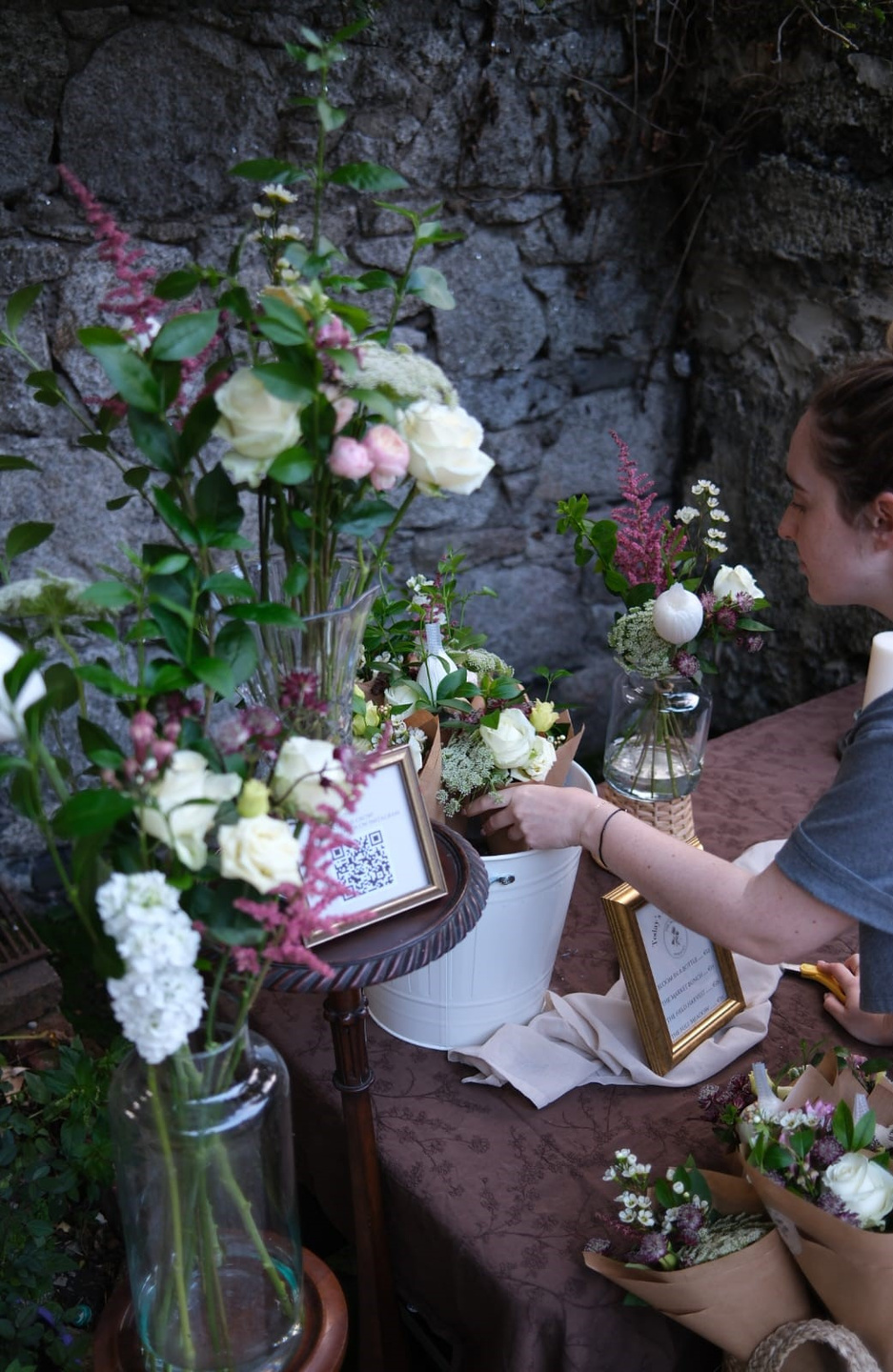 Aisling arranging stems at the studio table