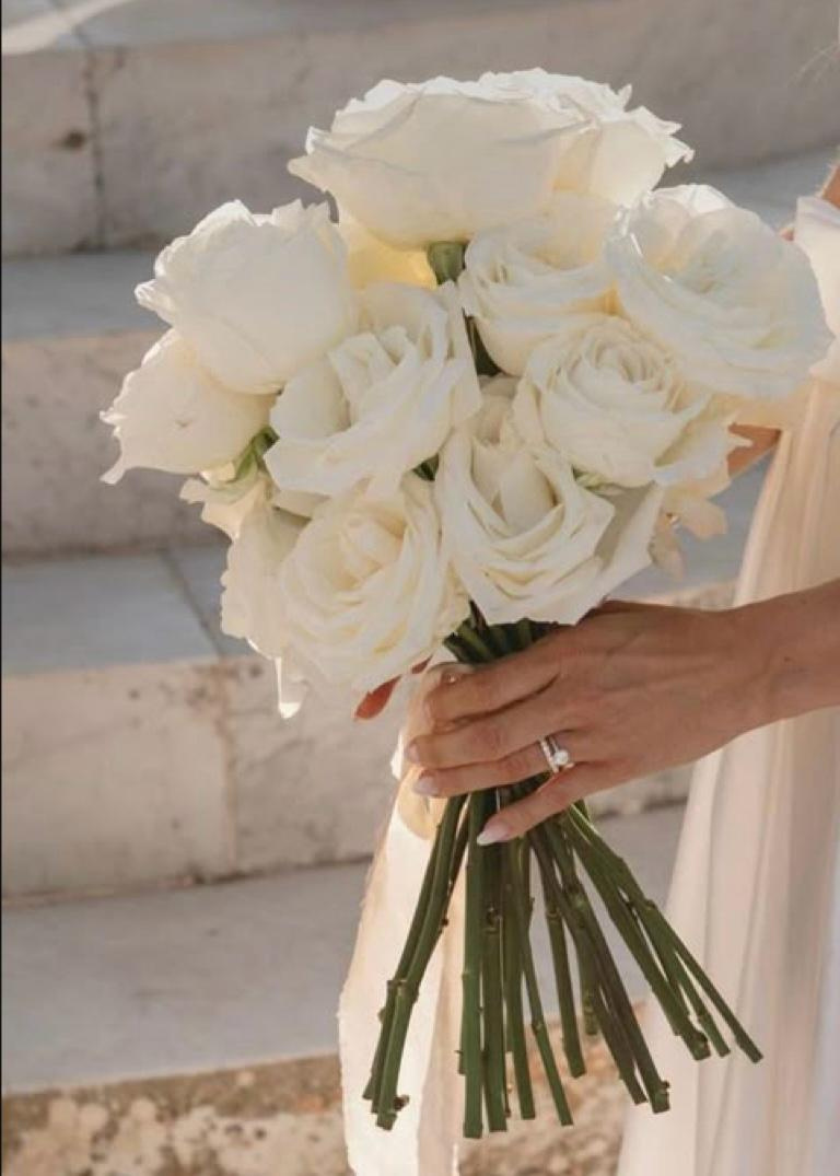A bride holding a white rose bouquet